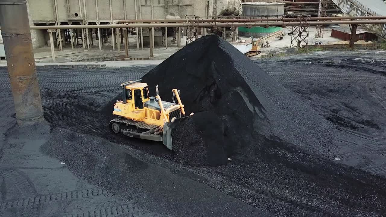 Bulldozer sorts coal. Extractive industry, anthracite. Coal industry.