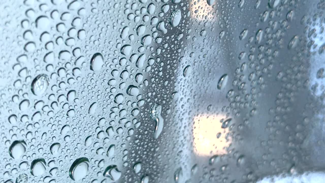 Driver's side car window getting rinsed off at an automatic car wash.