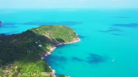 Beautiful-azure-sea-texture-surrounding-cape-of-tropical-island-with-rocky-coastline-and-green-rain-forest-in-Thailand