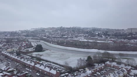 Sideways-tracking-drone-shot-of-snowy-Exeter-over-the-River-Exe