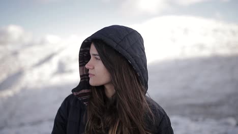 tourist in outerwear against high ridges in wintertime