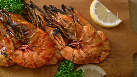 grilled tiger prawns or shrimps with lemon on wood board