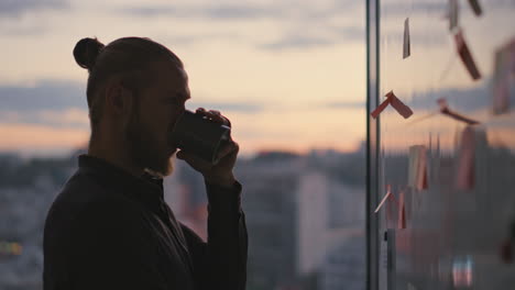 Silueta-De-Hombre-Bebiendo-Té-En-El-Primer-Plano-De-La-Sala-Al-Atardecer.-Freelancer-Buscando-Pegatinas