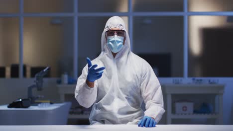 caucasian male medical worker wearing protective clothing and mask using virtual digital interface i