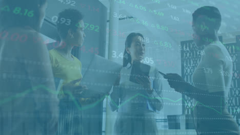 Animation-of-trading-board,-diverse-female-coworkers-discussing-holding-laptop-and-digital-tablet