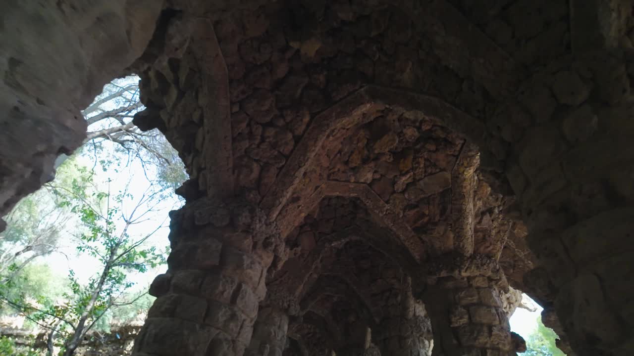 An architectural stone archway in Park Güell, Barcelona, creating a historic vibe
