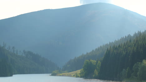 slide up sance drinking water reservoir with a natural valley full of hills and mountains around the water level which moves in a strong wind