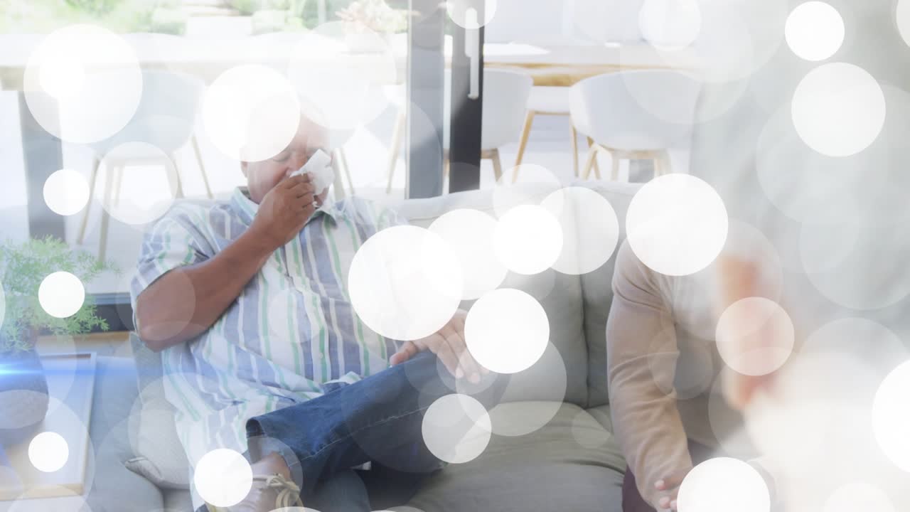 Senior man shifting adjusting shirt, reaching tissue and wiping during health talk, bokeh obscuring