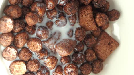 vertiendo leche sobre el cereal de chocolate