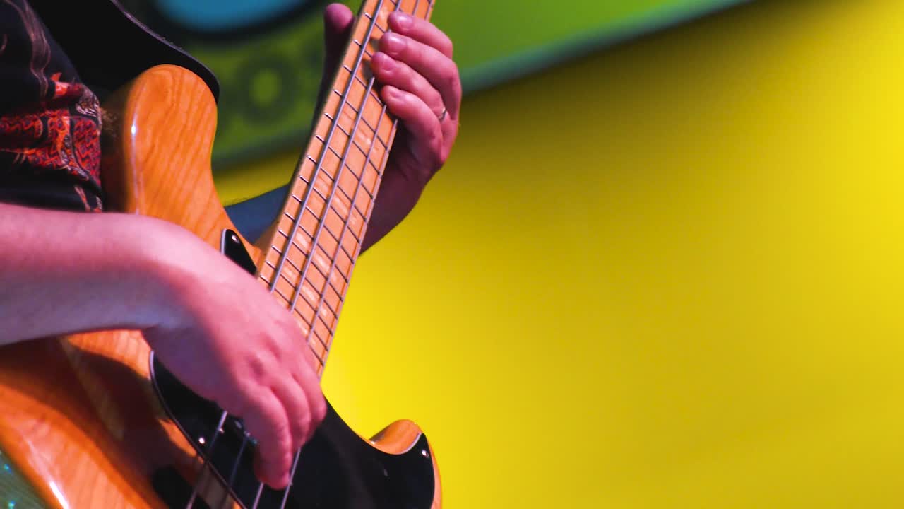 Elektro gitarıyla tutkuyla performans sergileyen profesyonel bir müzisyenin yakın çekim görüntüsü.