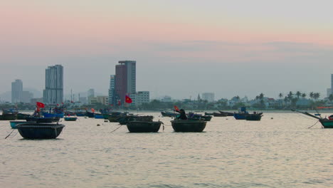 Static-shot-of-the-skyline-in-Da-Nang-with-boats-floating-in-the-bay-during-sunset