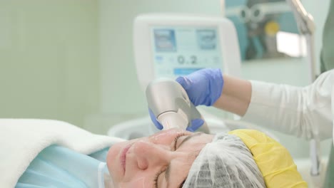 professional face skin rejuvenation, lifting procedure. cosmetologist uses modern ultrasound device. hardware cosmetology