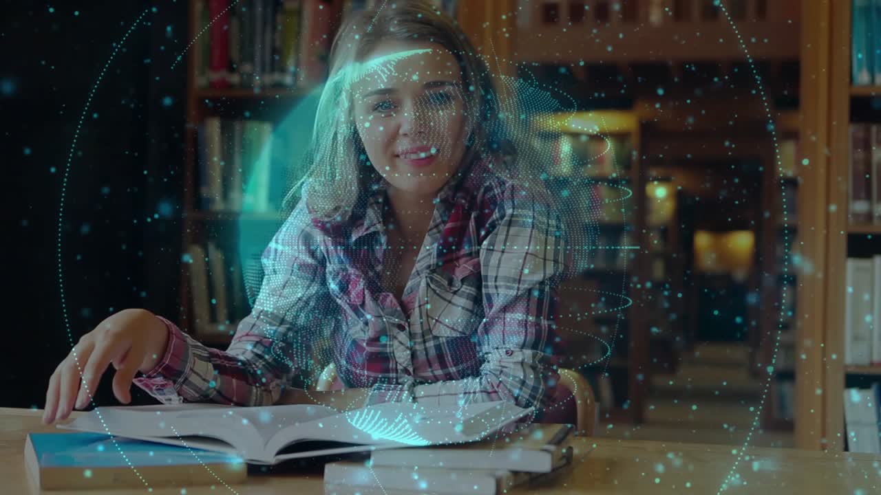 Female student leaning over book at library desk hologram globe circling head tapping page smiling
