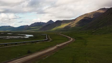 camioneta conduciendo por la carretera del glaciar portage y lanzando el valle de portage a lo largo del oleoducto trans alaska junto a las montañas - vista aérea amplia después del disparo