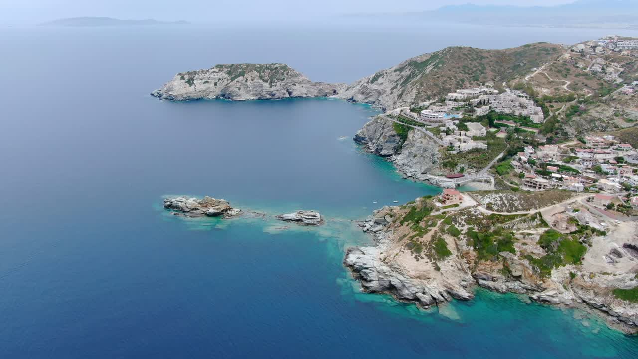 Wide angle dolly in drone aerial shot of beautiful beaches, houses, hills, and mountains in Creta Islands, Greece during the day