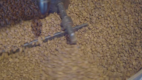 close-up of coffee beans being roasted in a machine