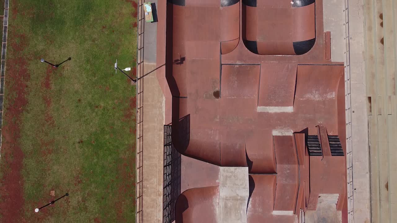 avión no tripulado de alta altitud mirando hacia abajo sobrevolando un parque de patinaje vacío y el parque circundante