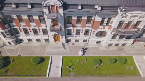 bride-dances-and-walking-groom-watches-on-street-aerial-view