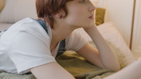 thoughtful girl lying on the bed, then turns to at side look at the ceiling