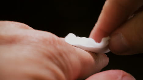 man wipes hand with cotton antiseptic pad to disinfect skin