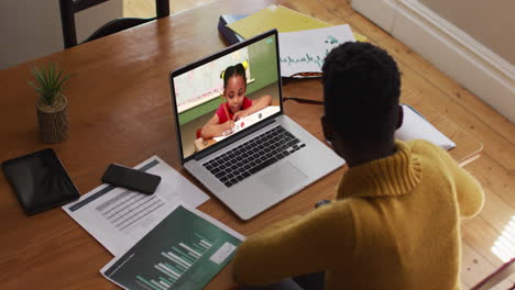 african american female teacher using laptop on video call with schoolgirl