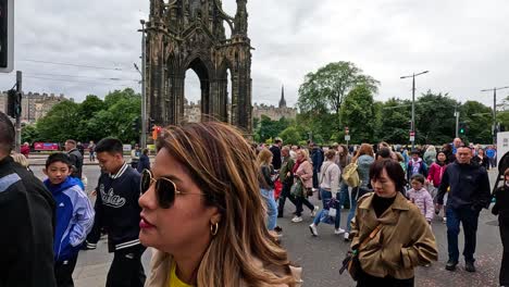 gente cruzando la calle cerca del monumento de scott