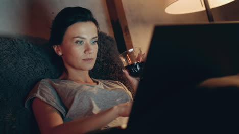 Mujer-Usando-La-Computadora-Tarde-En-La-Habitación.-Chica-Trabajando-En-Un-Cuaderno-Con-Una-Copa-De-Vino.