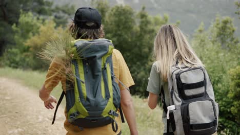 a happy couple backpackers walking by hills, stop to take a selfie