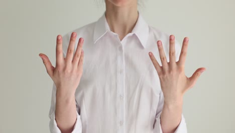 person gesturing with hands in a white shirt