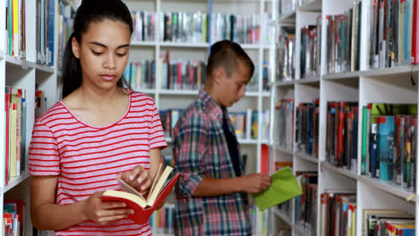 Schoolgirl-reading-book-in-library