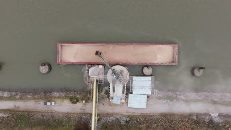 top down aerial footage of grain being off loaded from a barge by a crane in chattanooga, tn.
