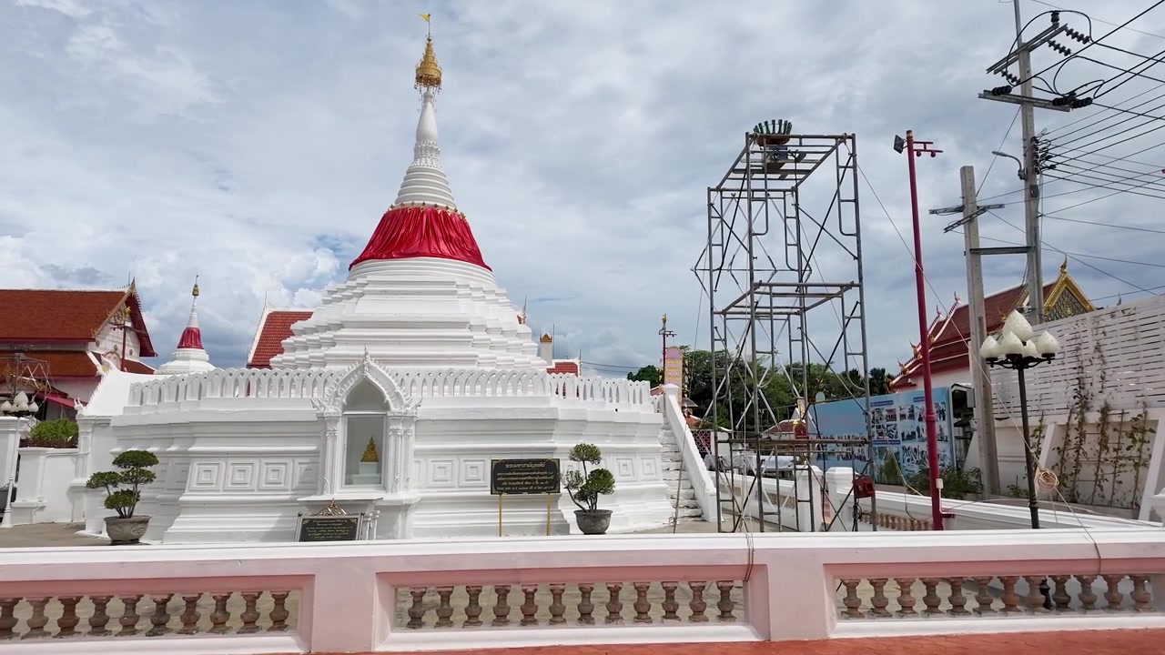 Inquadratura ampia statica di uno stupa bianco inclinato sotto un cielo nuvoloso in Thailandia