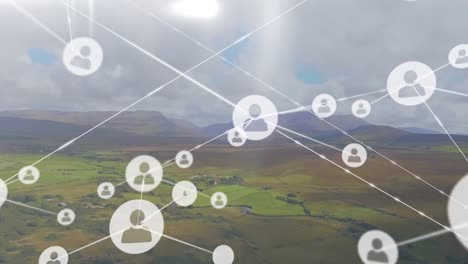 Animation-of-network-of-profile-icons-agains-aerial-view-of-grassland