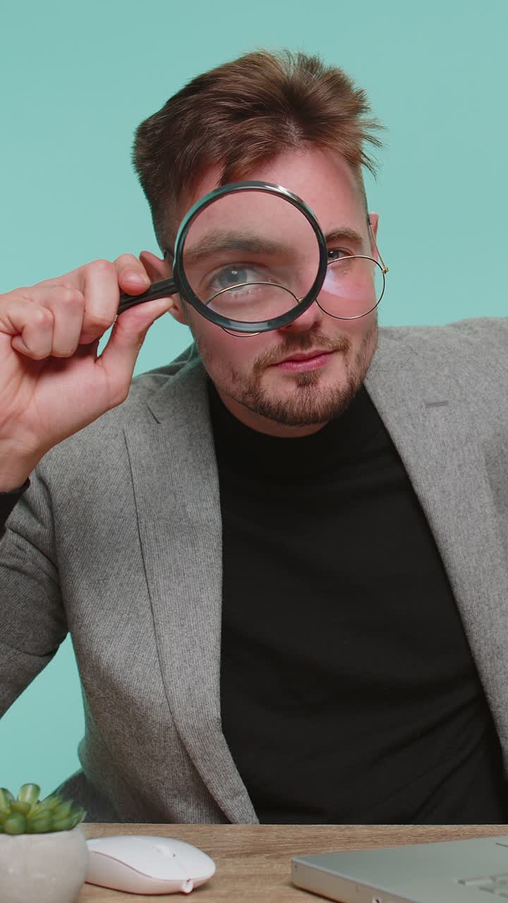 Investigator researcher scientist businessman holding magnifying glass near face analyzing searching