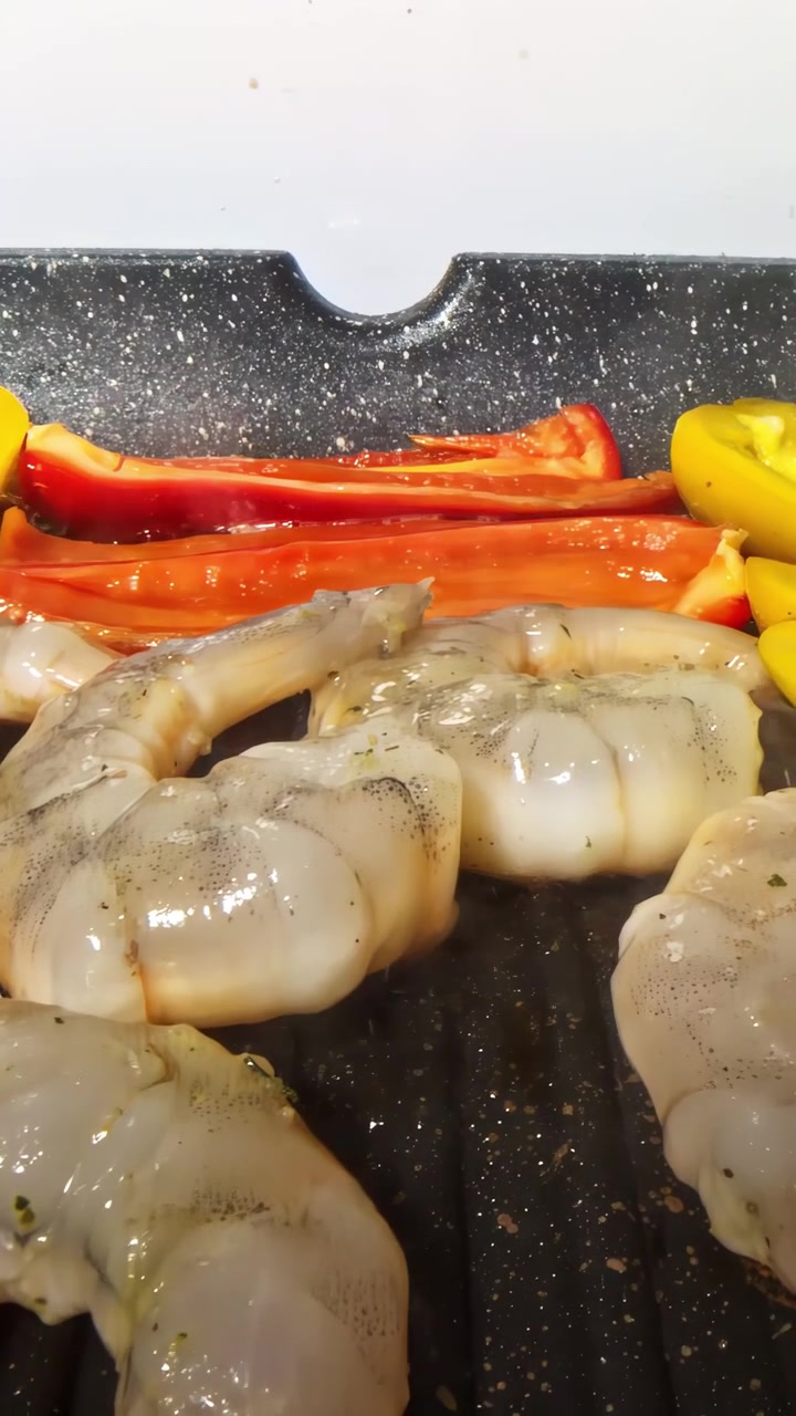 Juicy shrimp and vibrant bell peppers cook on a hot grill, creating a savory aroma.
