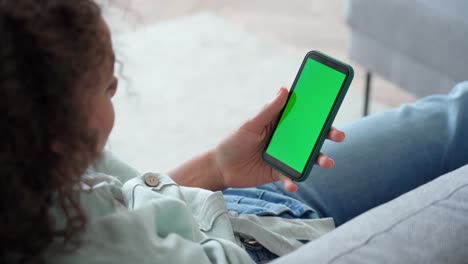 over shoulder view of green blank empty mockup cell screen for advertising.