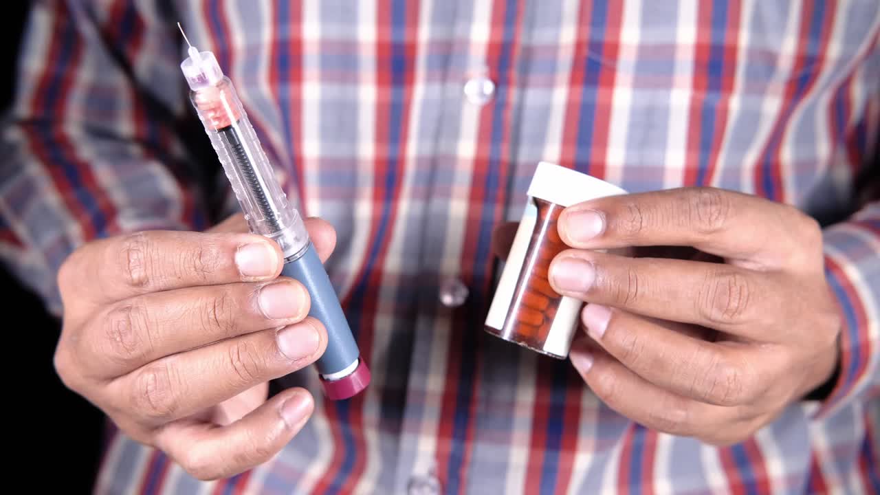 Persona che tiene una penna per insulina e un medicinale