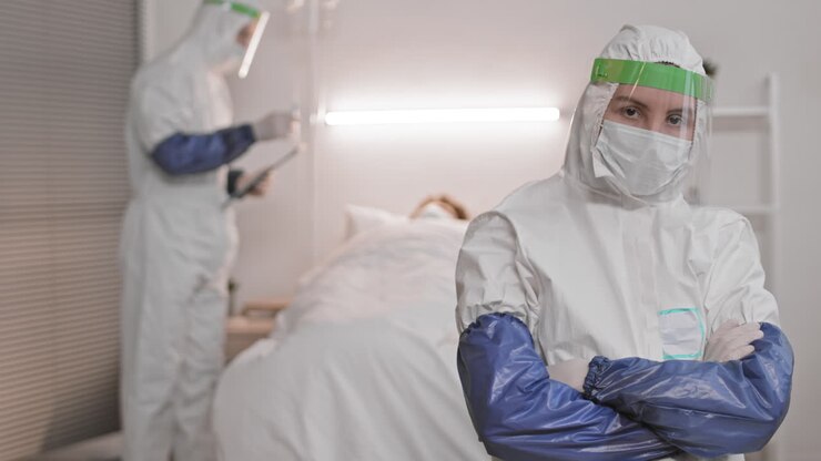 médico en traje de protección posando