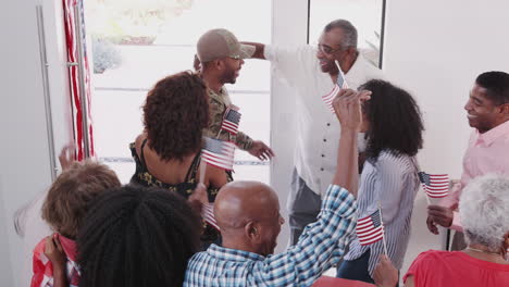 young black soldier returning to a surprise family welcome home party, elevated view