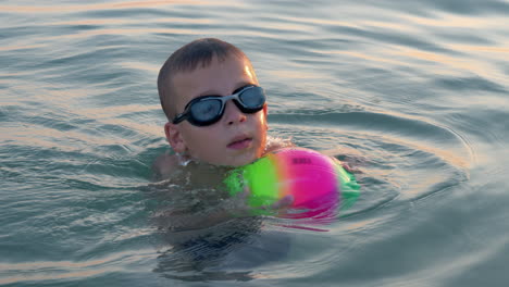 child bathing in the sea and having fun with ball