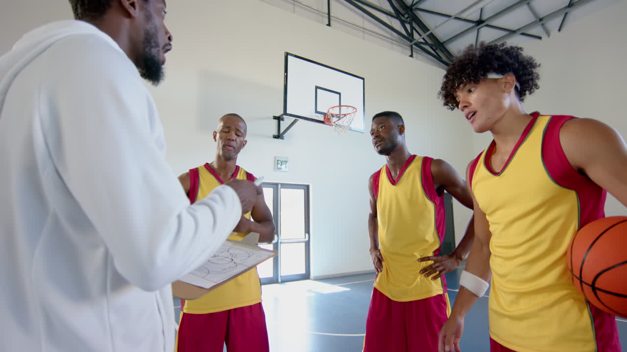 Diverse basketball team strategizes in a gym