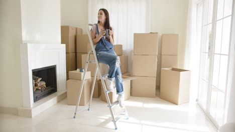 Young-woman-sitting-on-a-stepladder