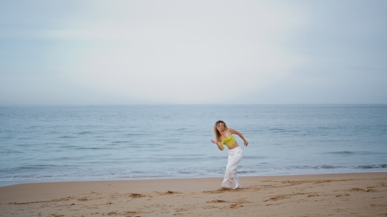 활기찬 댄서가 해변에서 저녁 바람을 즐기며 춤을 춘 여자