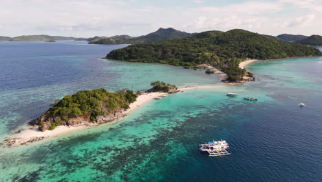 drone footage of coron island’s breathtaking beauty, featuring secluded beaches, lush greenery, and clear blue seas, philippines. revealing aerial footage of boat in anchored.