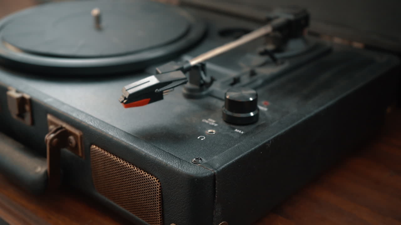 A hand turns on a turn table and turns up and down the volume.