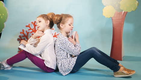 cute little girls are reading books. happy childhood. studio shooting of children