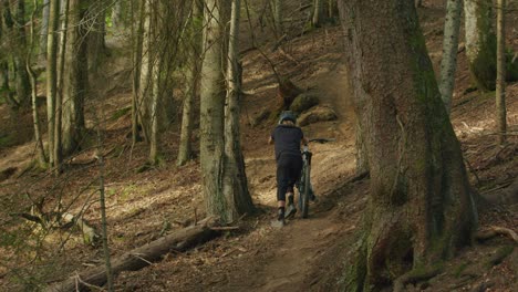 Mountainbiker-Schiebt-Sein-Fahrrad-Einen-Steilen-Hügel-Im-Wald-Hinauf