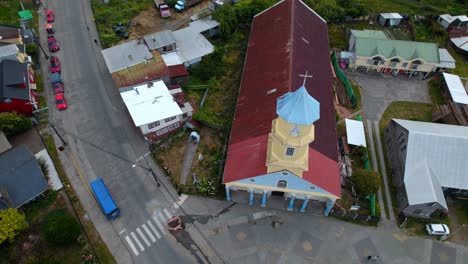 aerial drone fly top down patrimonial church chonchi in chiloé chile south american religious building at patagonia, streets and car traffic