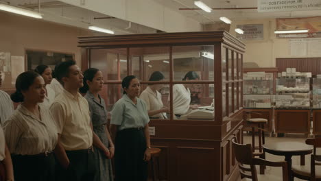 group of people in uniforms waiting in a vintage office setting