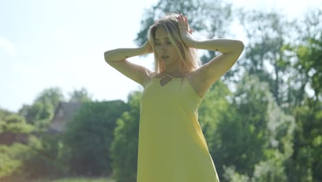 mujer con vestido amarillo bailando con gracia en el parque de verano